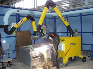 Сварщик работает при помощи вытяжного устройства